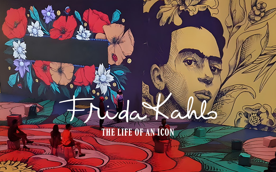 Frida Kahlo exhibit with floral art and visitors at Art Science Museum's Future World.