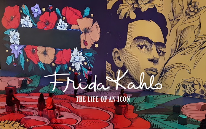Frida Kahlo exhibit with floral art and visitors at Art Science Museum's Future World.