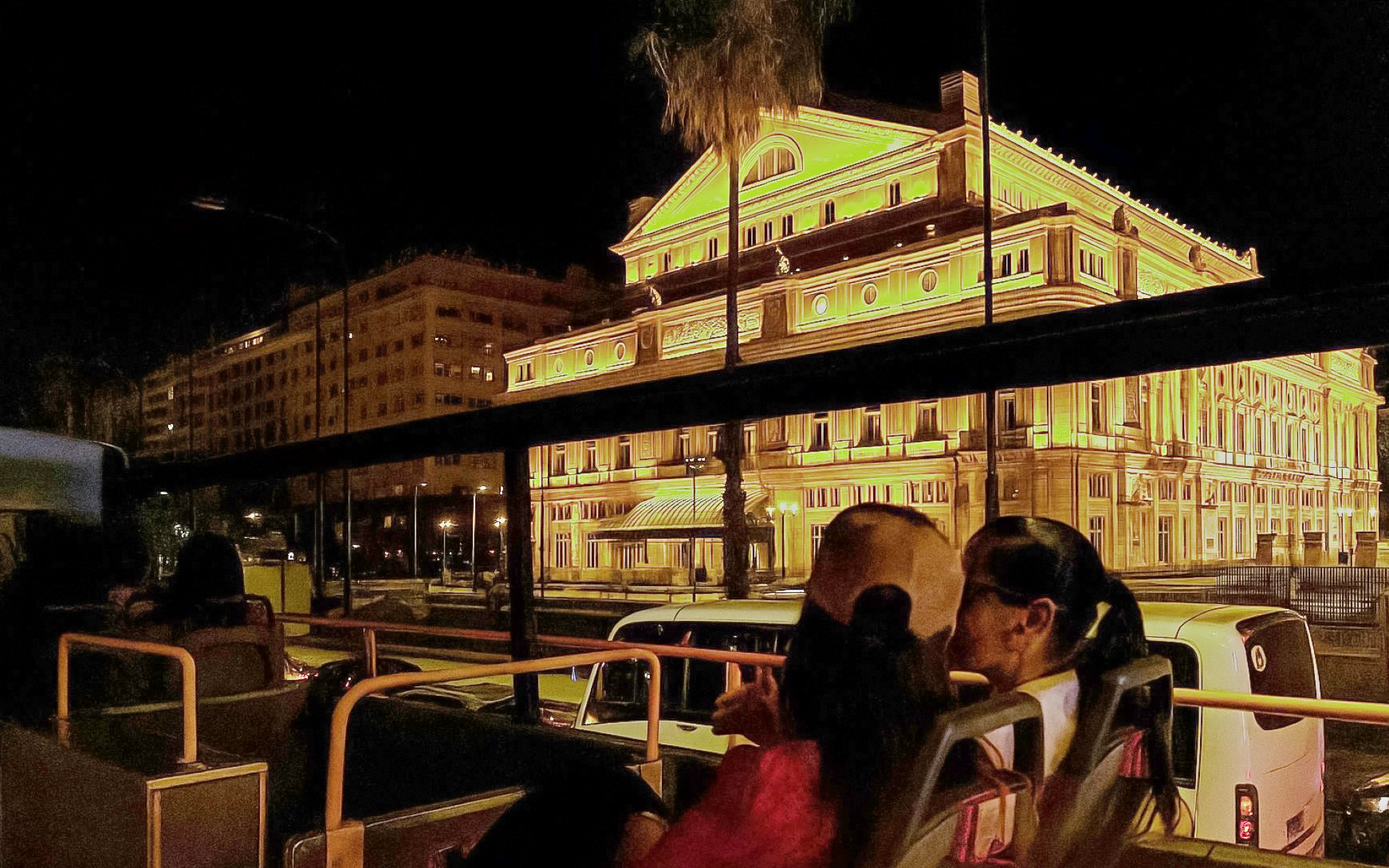 Open-top bus passing Teatro Colón at night during Buenos Aires myths and legends tour.