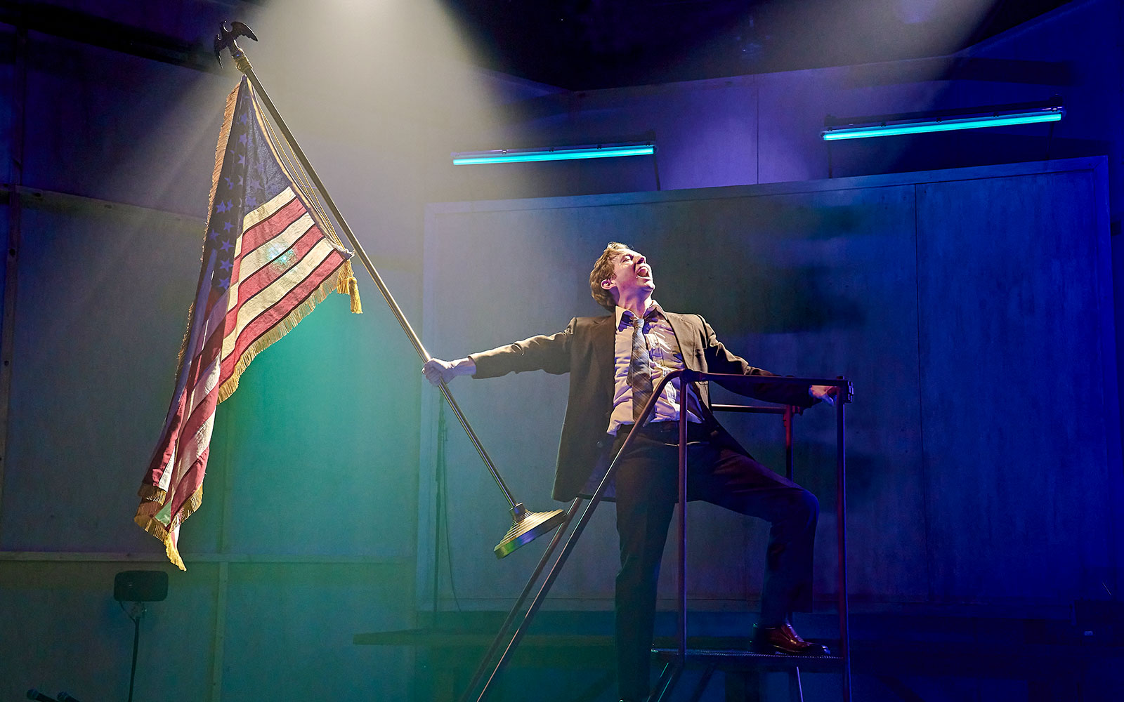Performer on stage holding an American flag during Kenrex show.
