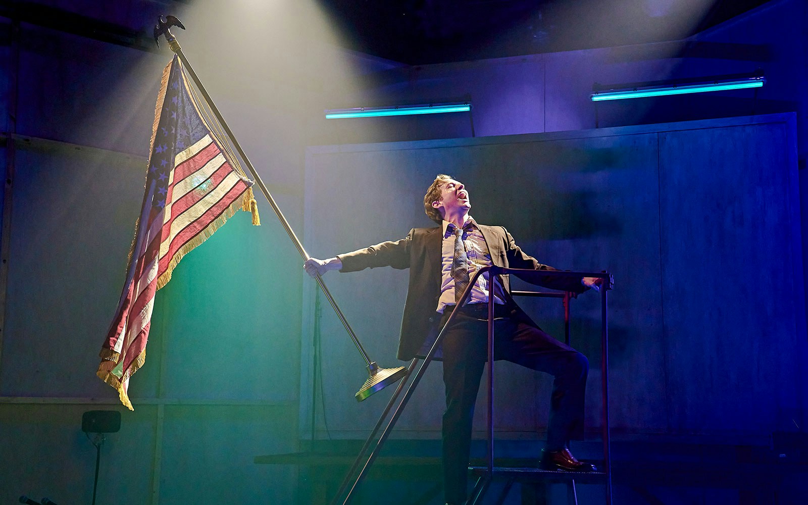 Performer on stage holding an American flag during Kenrex show.