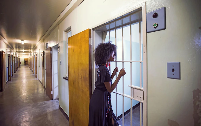 Visitor exploring a cell corridor on a Robben Island prison tour.