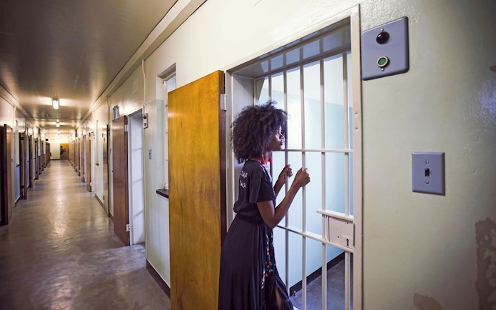 Visitor exploring a cell corridor on a Robben Island prison tour.