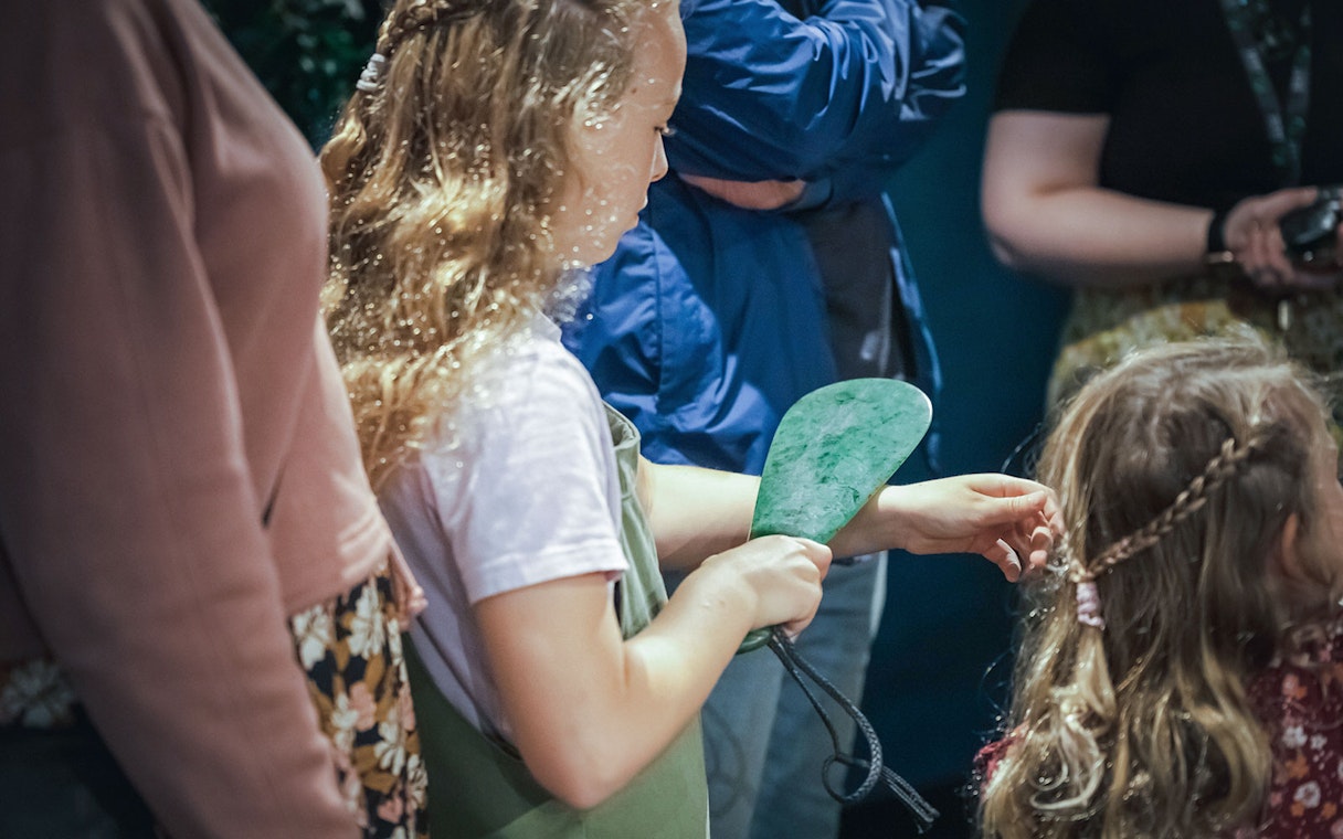 Child holding jade artifact during Mountain Jade Highlights Tour.