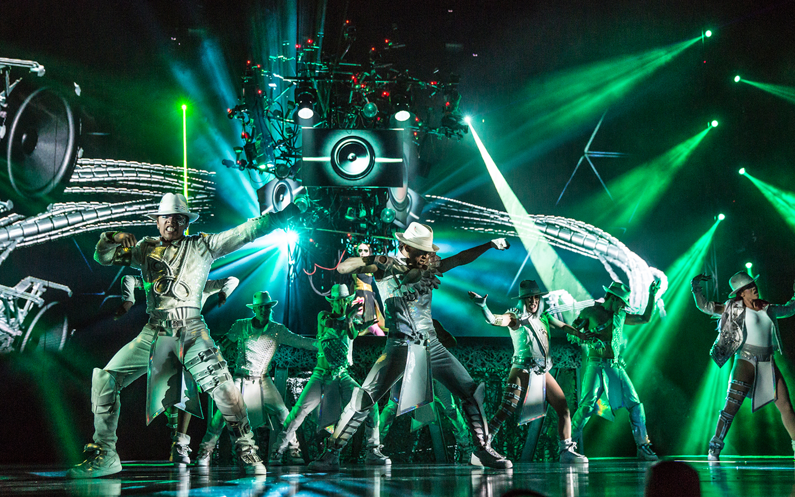 Performers dancing in Michael Jackson ONE show with vibrant green lights.