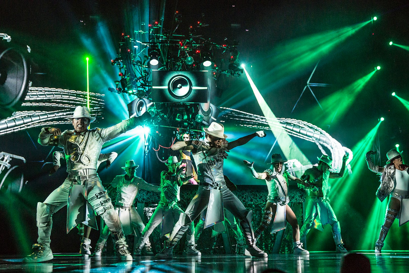 Performers dancing in Michael Jackson ONE show with vibrant green lights.
