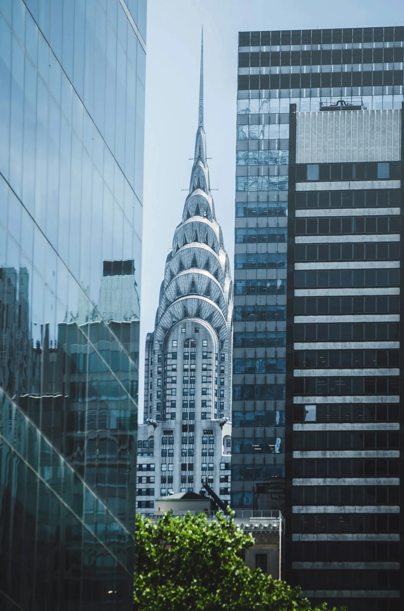 Chrysler Building spire framed by modern skyscrapers in New York City.
