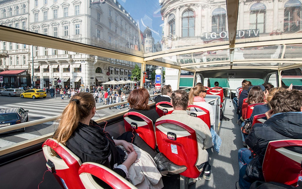 Passengers on a Vienna Hop-On Hop-Off bus touring city streets.
