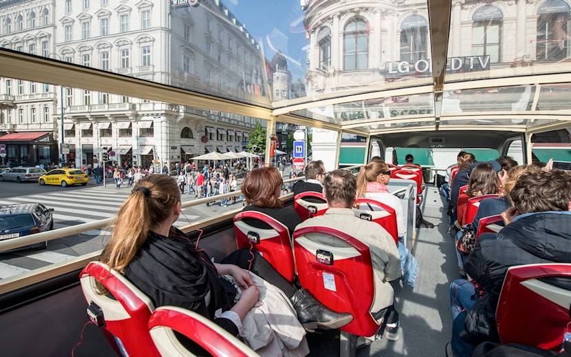 Passengers on a Vienna Hop-On Hop-Off bus touring city streets.