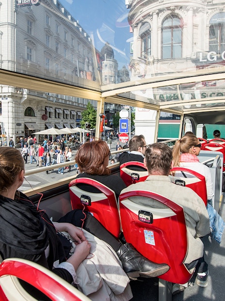 Passengers on a Vienna Hop-On Hop-Off bus touring city streets.