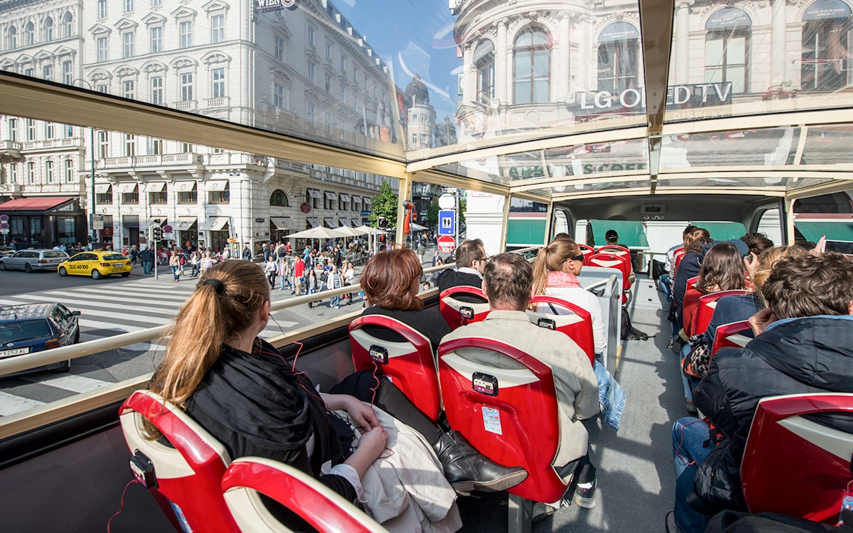Passengers on a Vienna Hop-On Hop-Off bus touring city streets.