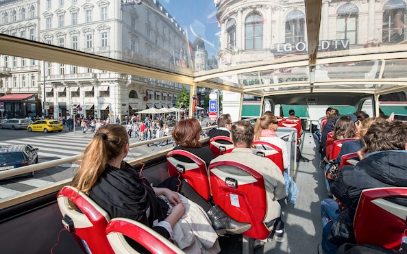 Passengers on a Vienna Hop-On Hop-Off bus touring city streets.