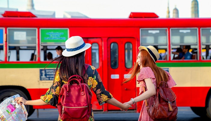 public transport bus at a city stop with passengers boarding.