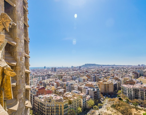 View of Barcelona from Sagrada Familia tower with cityscape and statue.