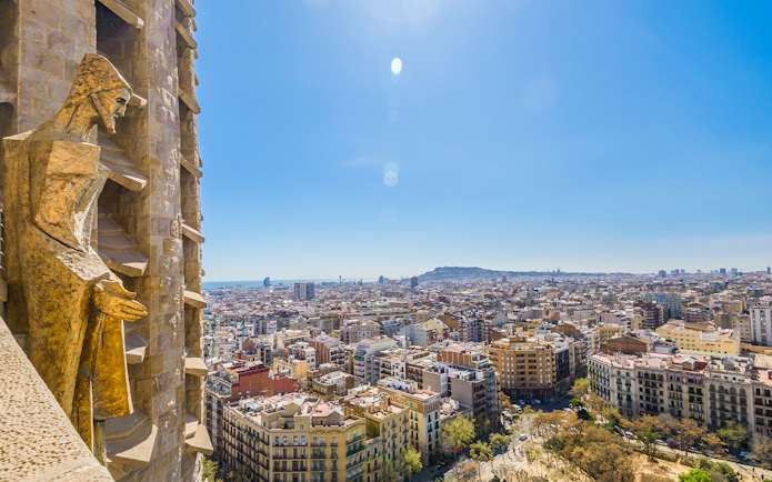 View of Barcelona from Sagrada Familia tower with cityscape and statue.