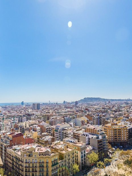 View of Barcelona from Sagrada Familia tower with cityscape and statue.