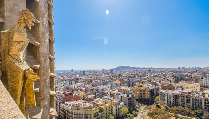 View of Barcelona from Sagrada Familia tower with cityscape and statue.
