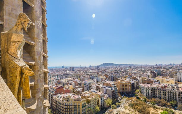 View of Barcelona from Sagrada Familia tower with cityscape and statue.