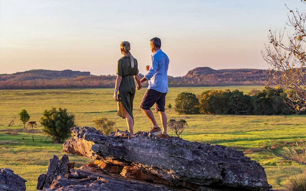 Couple standing on rock overlooking Kakadu National Park landscape during 1-Day Guided Kakadu Wilderness Escape.
