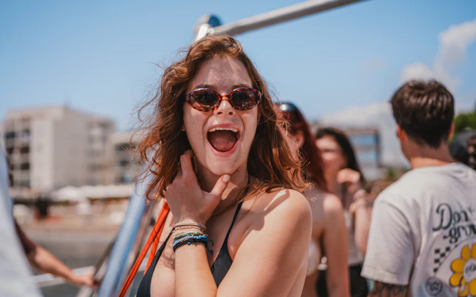 Tourist enjoying Cruise Crush Boat Party with friends in sunny weather.