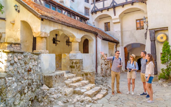 Tour group exploring the courtyard of Dracula Castle in Bran, Romania.