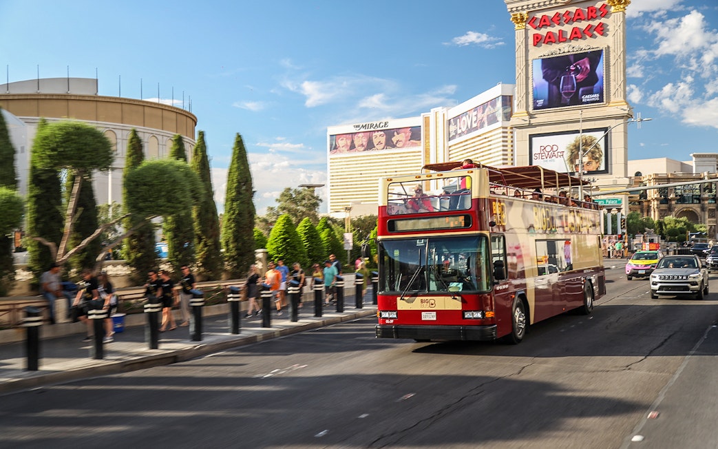 Open-top bus on Las Vegas Strip near Caesars Palace during Big Bus Hop On Hop Off tour.