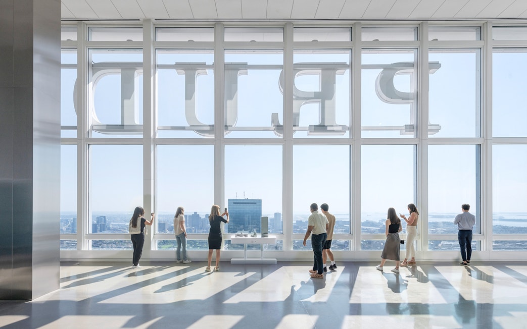 Tourists at Boston observation deck viewing city skyline.