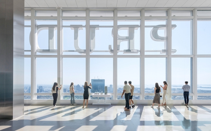 Tourists at Boston observation deck viewing city skyline.