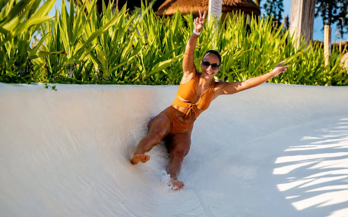 Person enjoying a water slide at Luna Beach Club.