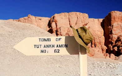 Sign pointing to Tutankhamun's tomb in Luxor, Egypt, with a hat on top.