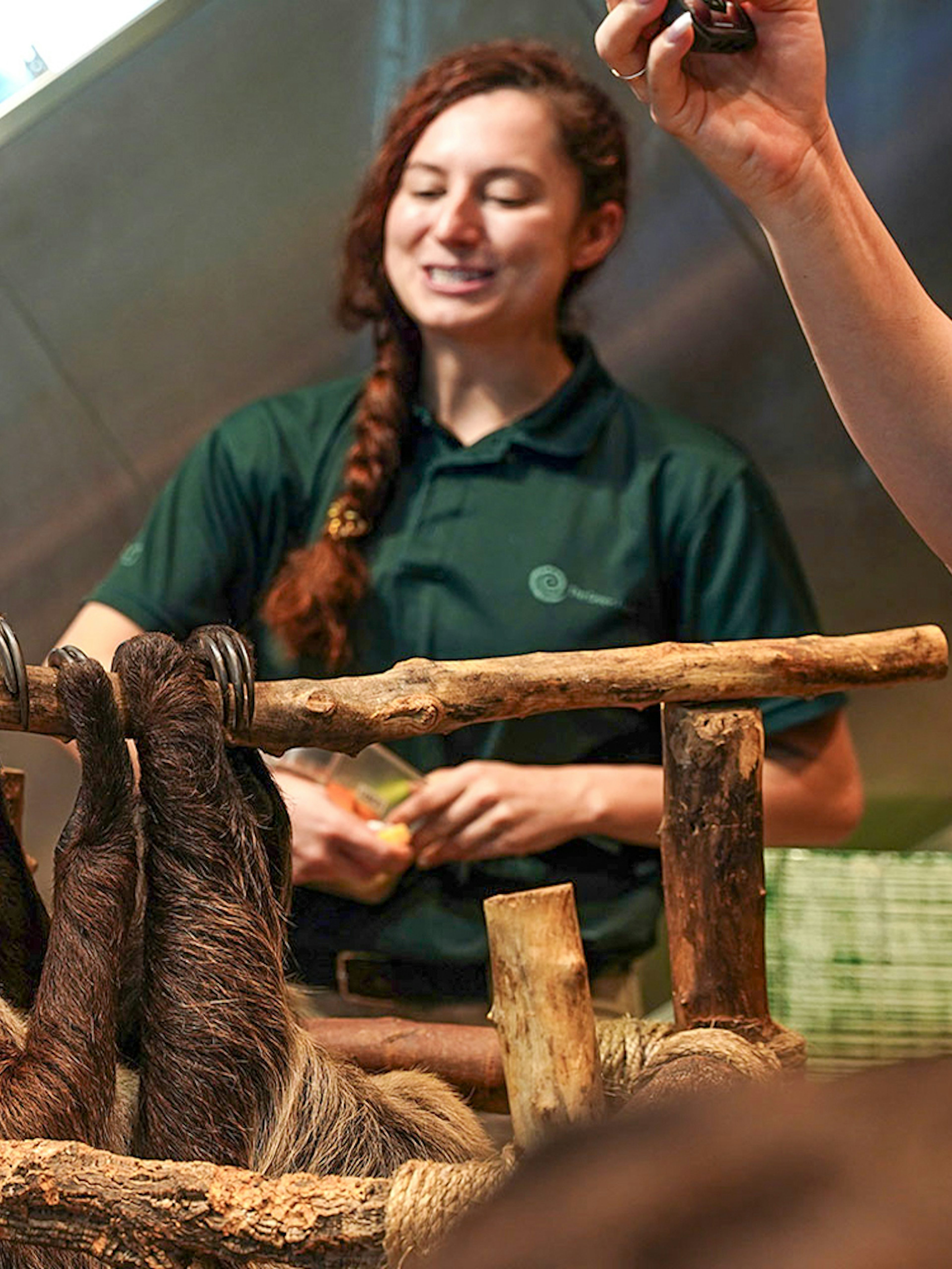 Family interacting with a sloth at Green Planet Dubai.