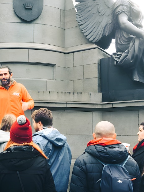 Tour guide leading a group at a monument in Dublin.