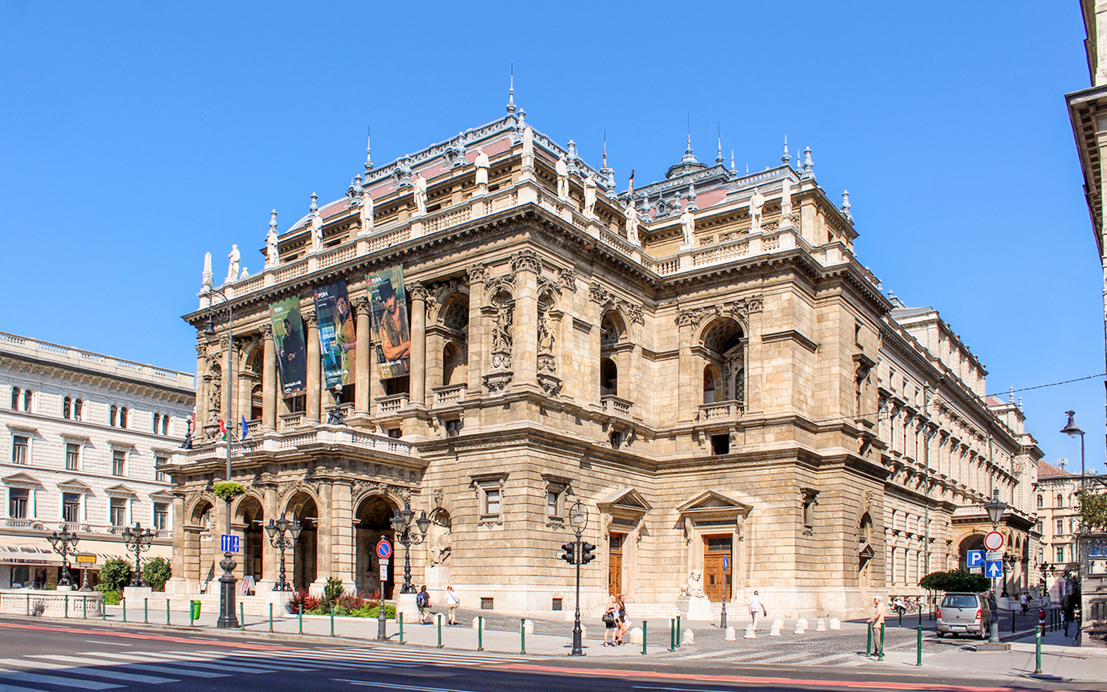Facade of the Hungarian State Opera in Budapest with ornate architecture and statues.