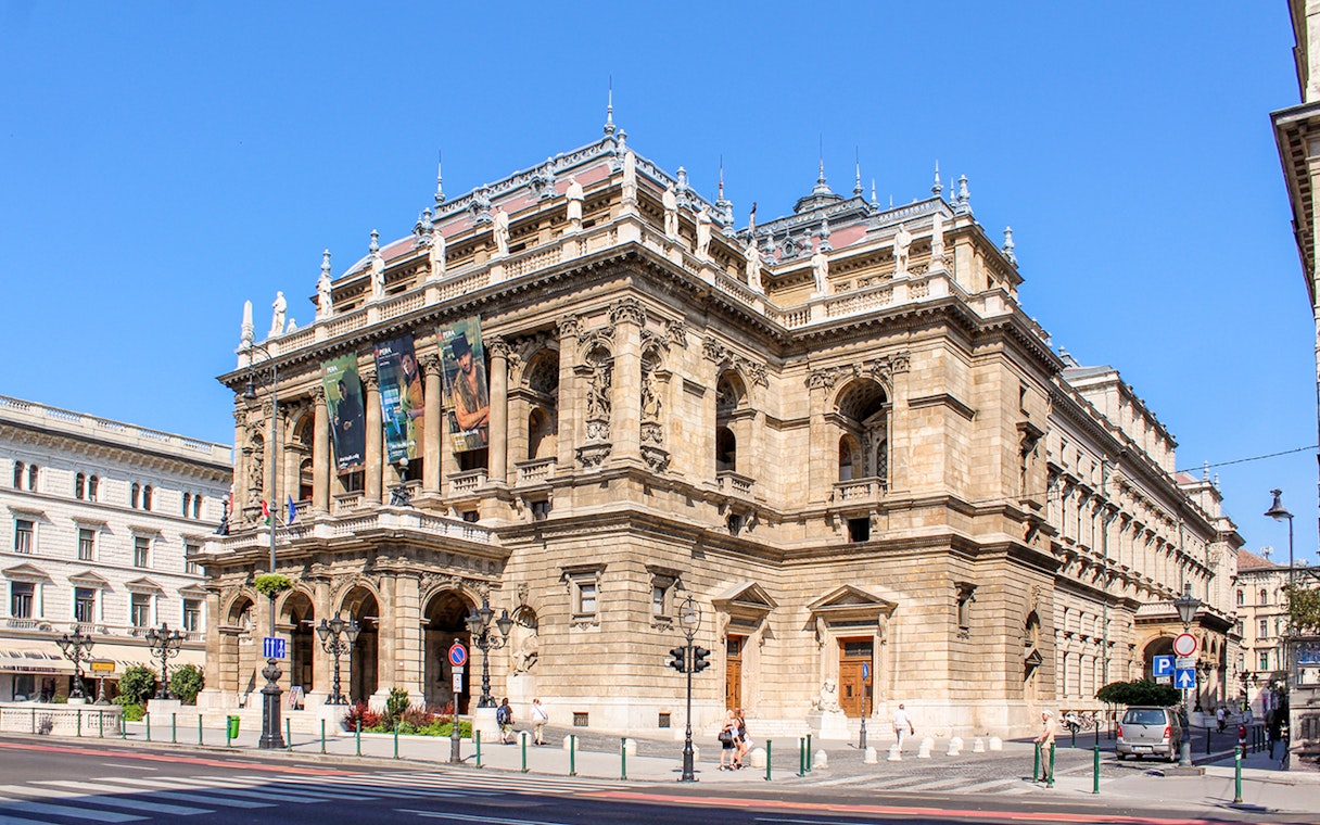 Facade of the Hungarian State Opera in Budapest with ornate architecture and statues.