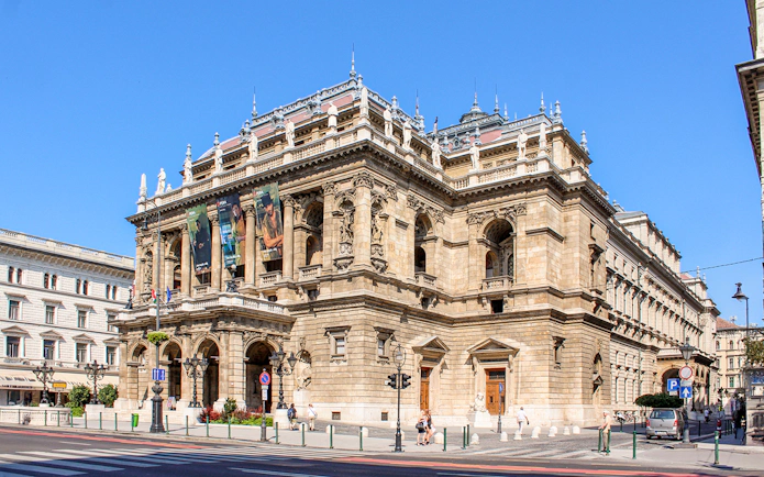 Facade of the Hungarian State Opera in Budapest with ornate architecture and statues.