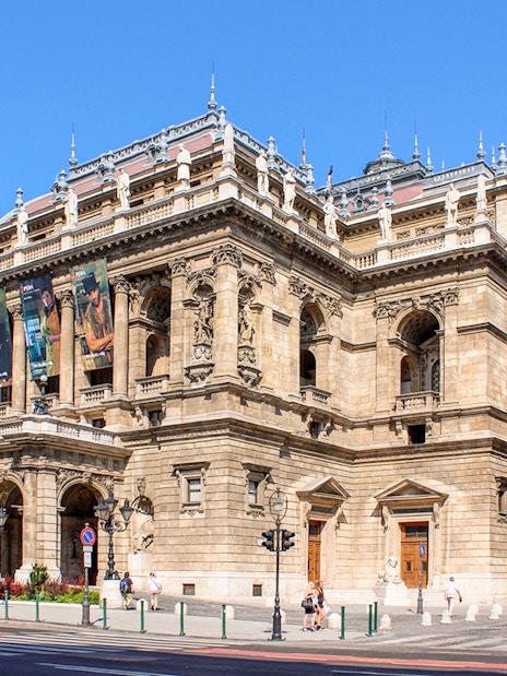 Facade of the Hungarian State Opera in Budapest with ornate architecture and statues.