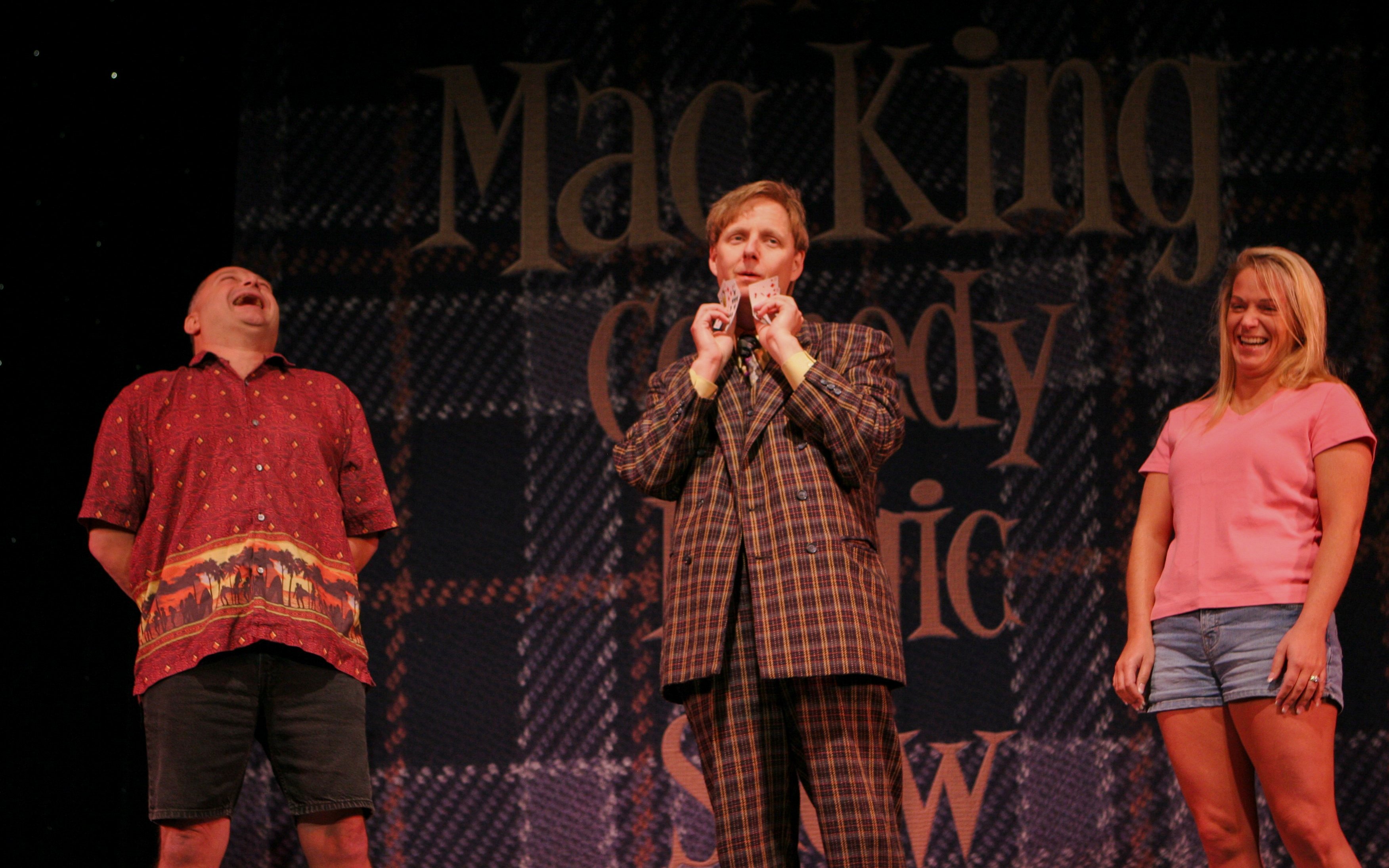 Magician performing card trick with audience members at The Mac King Comedy Magic Show, Vegas.