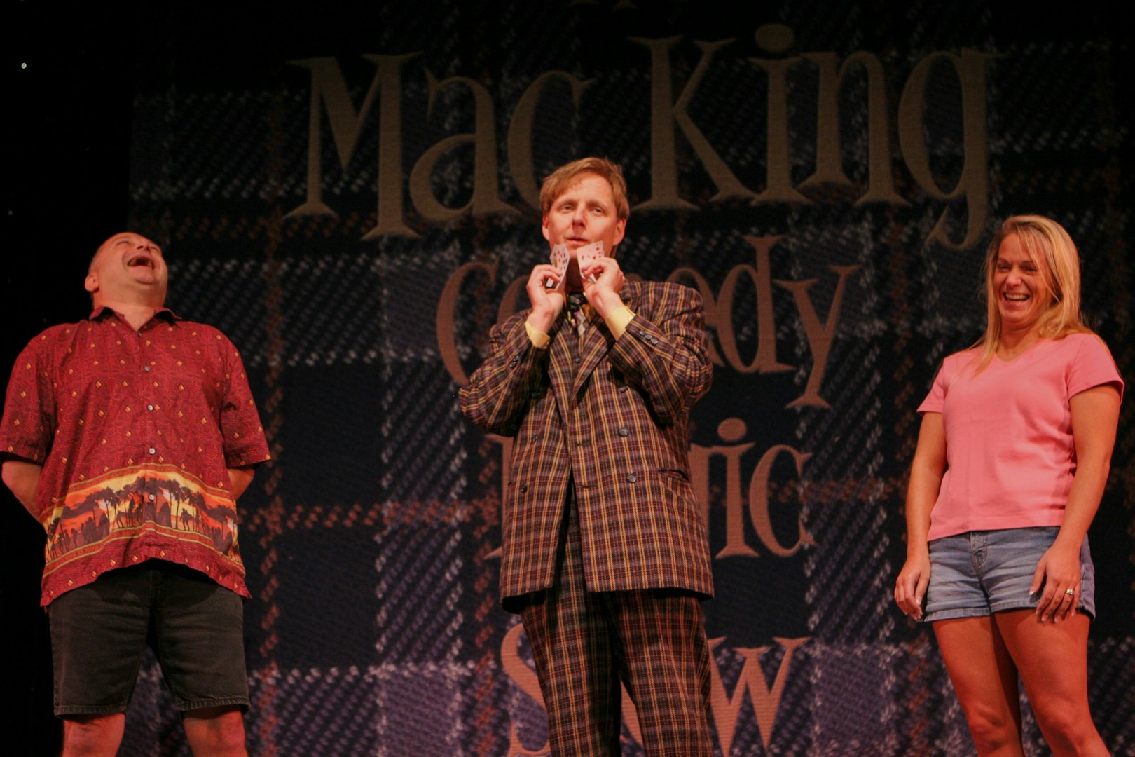 Magician performing card trick with audience members at The Mac King Comedy Magic Show, Vegas.