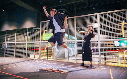 Man jumping on trampoline at RED° TOKYO TOWER indoor attraction.