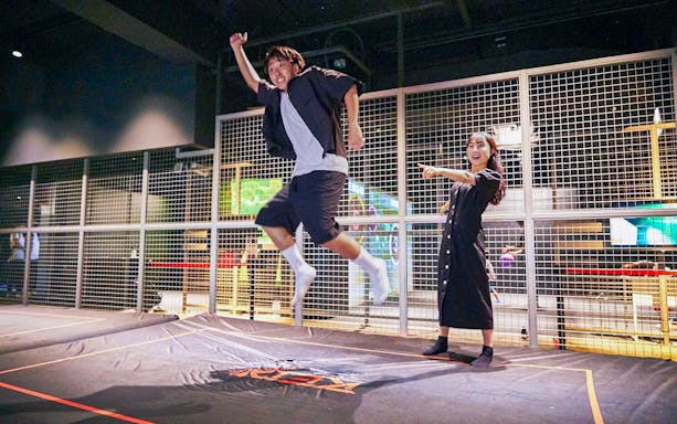 Man jumping on trampoline at RED° TOKYO TOWER indoor attraction.