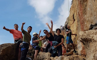 Group rock climbing with guide on Guia Cascais cliffs, Portugal.