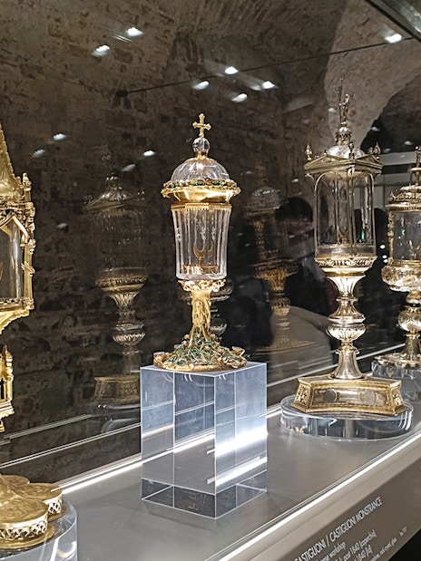 Golden religious artifacts displayed at Duomo Milan Museum exhibit.