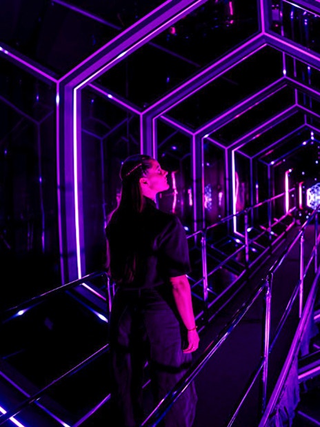 Guest exploring neon-lit tunnel at Amaze Amsterdam.