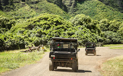 UTVs driving through lush greenery at Kualoa Ranch, Oahu, Hawaii.