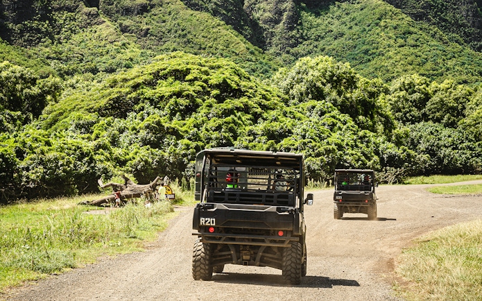 UTVs driving through lush greenery at Kualoa Ranch, Oahu, Hawaii.