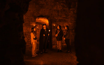 Guests exploring underground vaults on the Doomed, Dead and Buried tour in Edinburgh.
