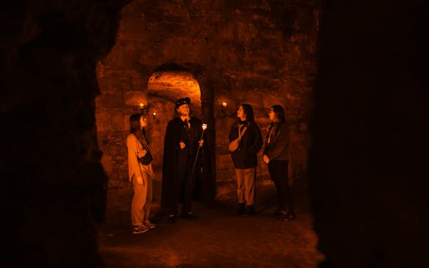Guests exploring underground vaults on the Doomed, Dead and Buried tour in Edinburgh.