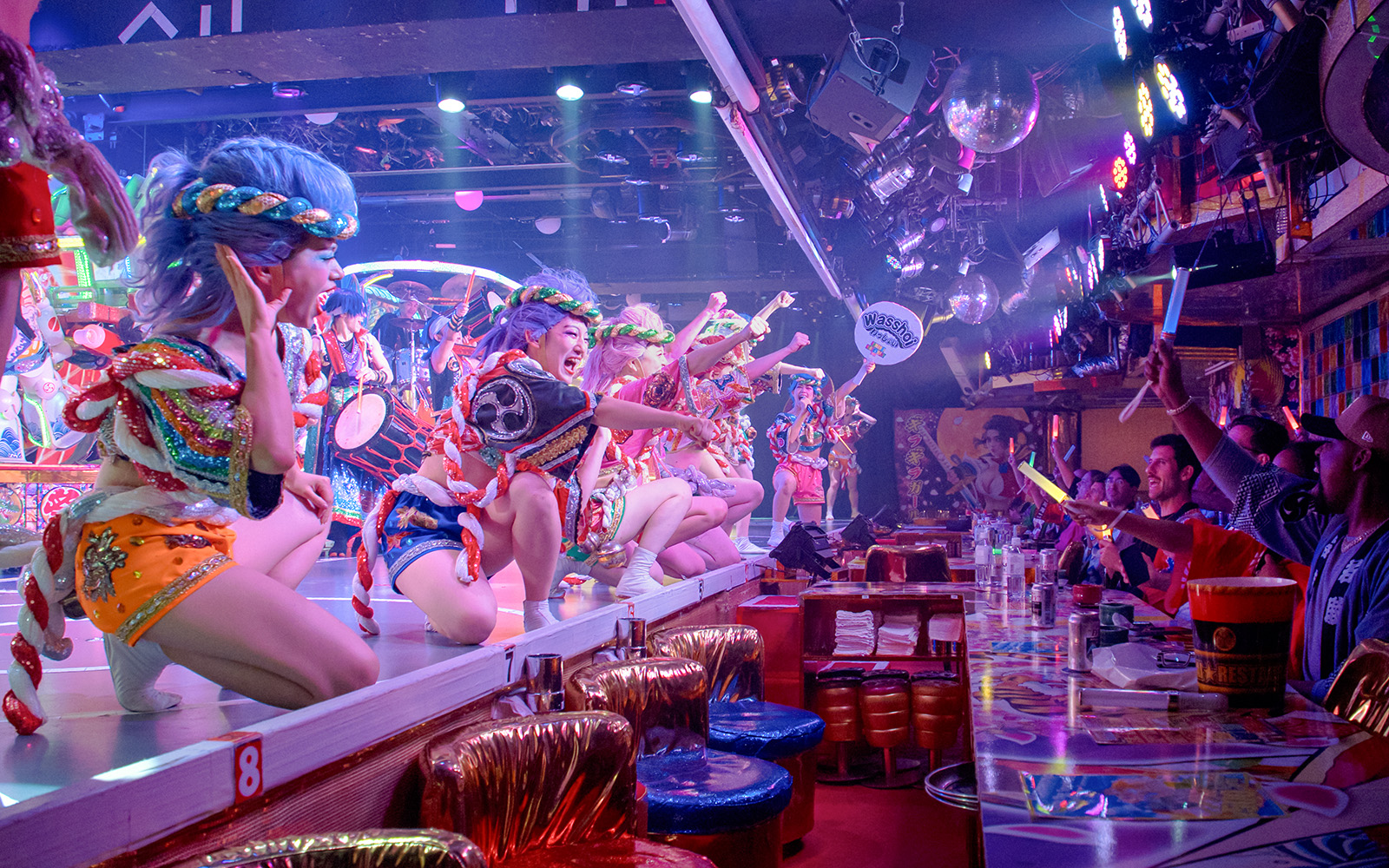 Performers in colorful costumes entertain diners at a Samurai Restaurant Show.