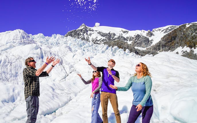 Family playing with snow on Franz Josef Glacier tour.