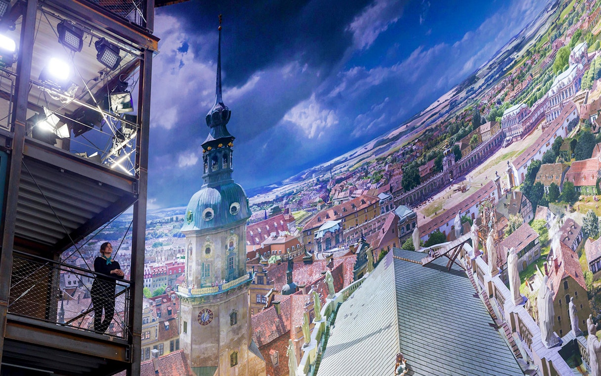 Panometer Dresden interior with panoramic cityscape and visitor on viewing platform.